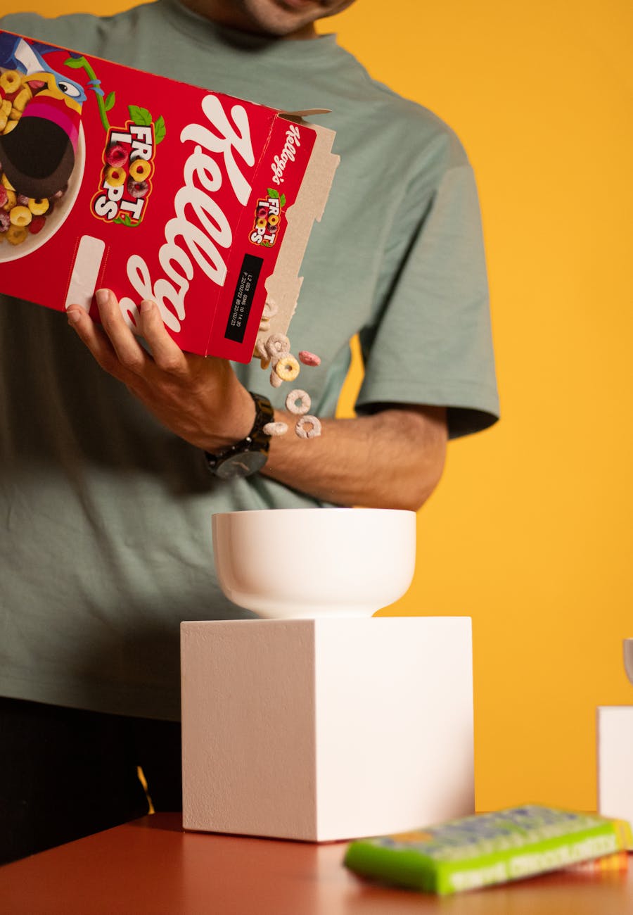 a person pouring cereals in white bowl