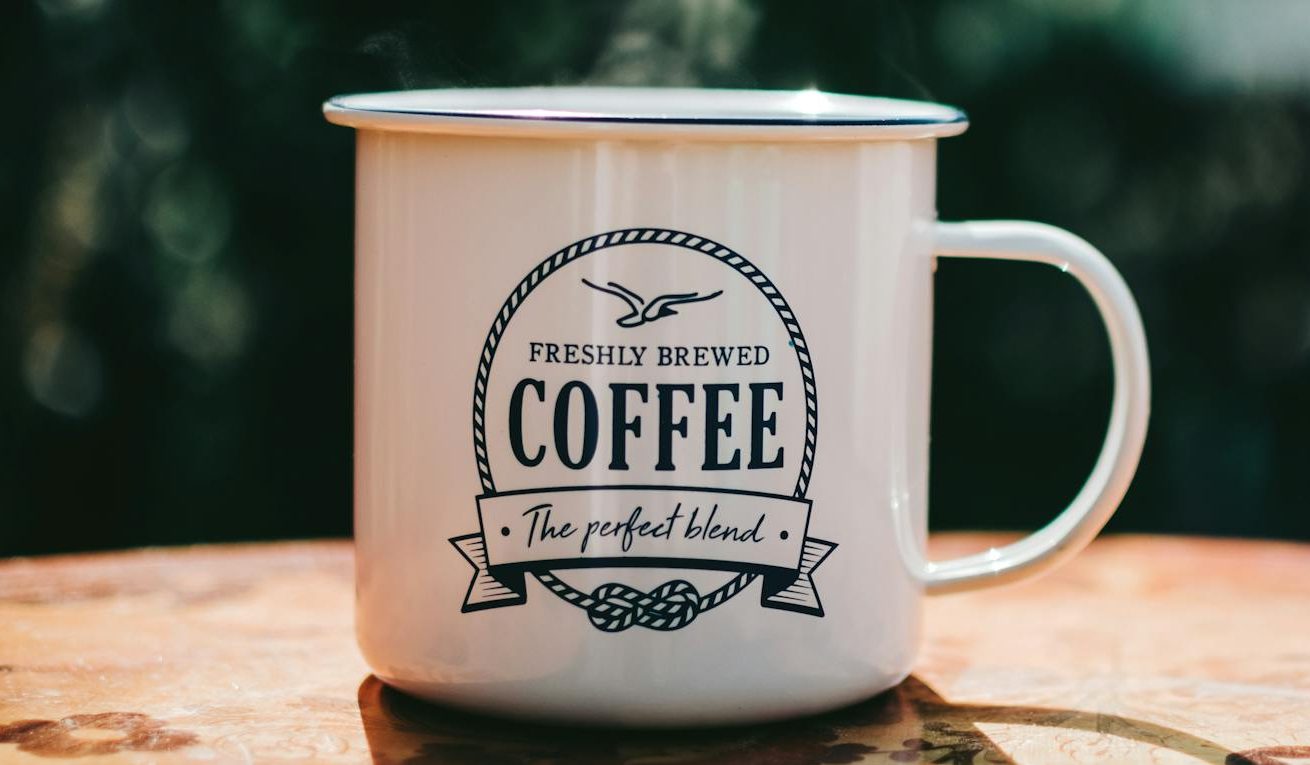 white coffee mug on brown surface