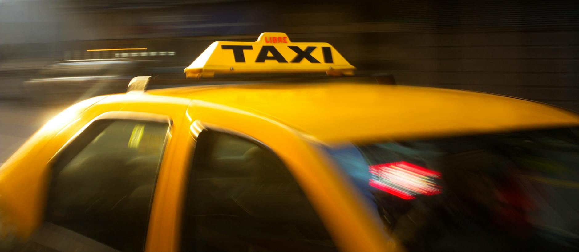 panning photography of yellow taxi