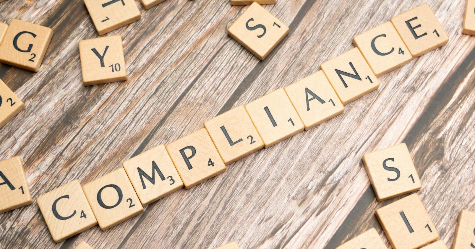 the word compliance written in scrabble letters