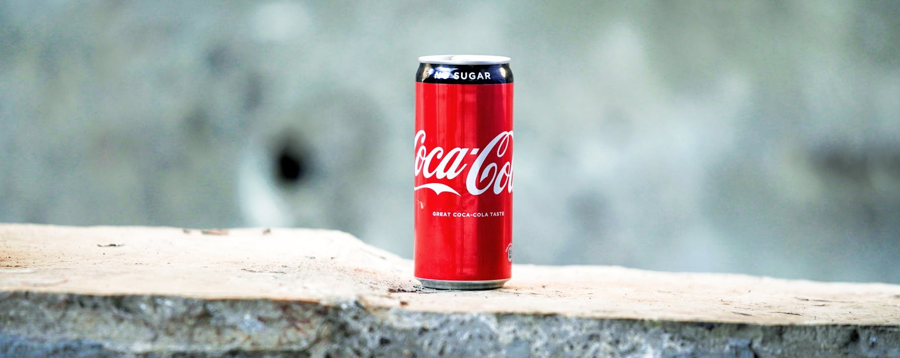 coca cola can on brown concrete surface