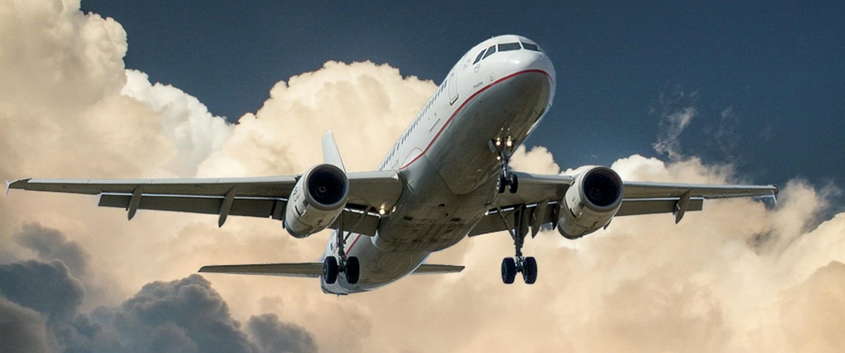white and red plane beside clouds low angle photography