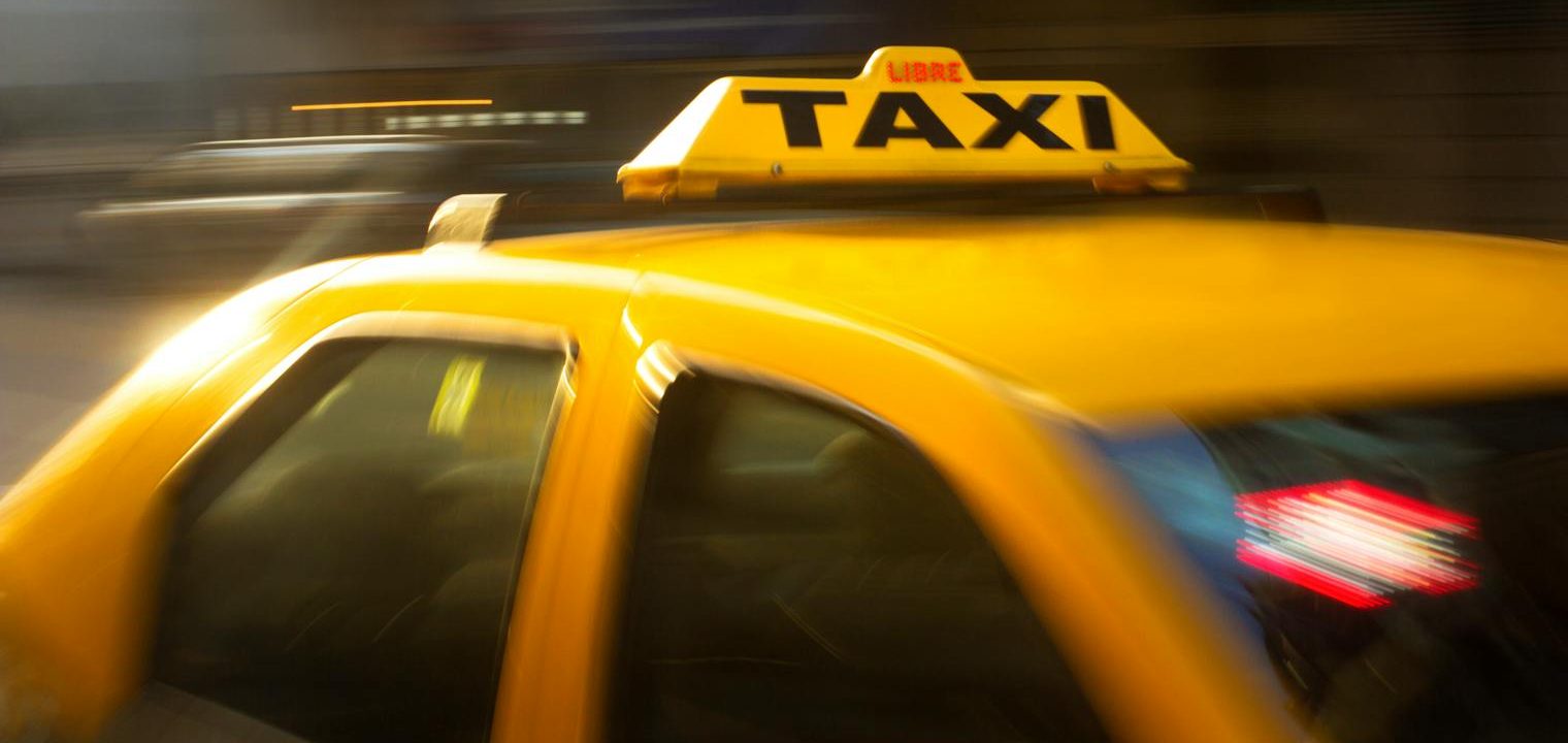 panning photography of yellow taxi