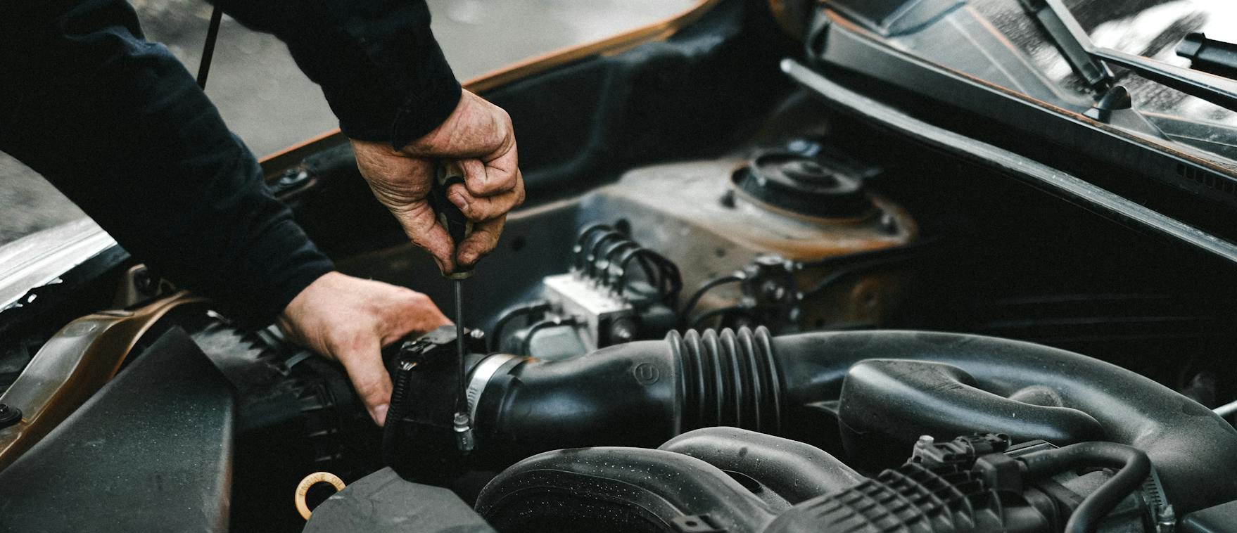 an auto mechanic checking the engine of a car