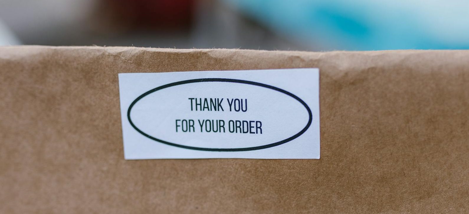 close up photo of a sticker on a white paper bag
