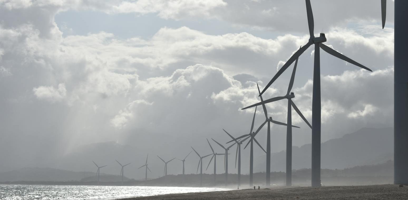windmills on seashore under white clouds