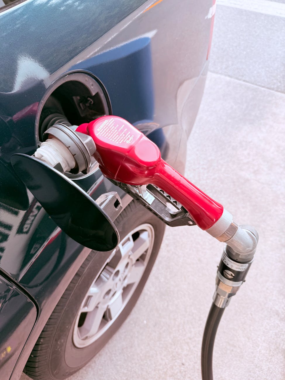 red gas pump refueling a car at station
