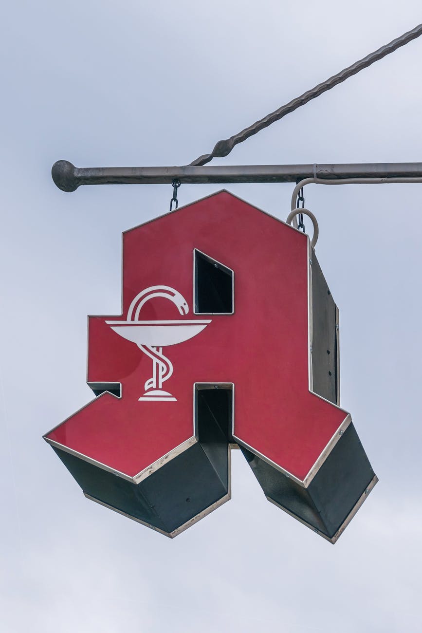 red pharmacy sign with snake icon outdoors