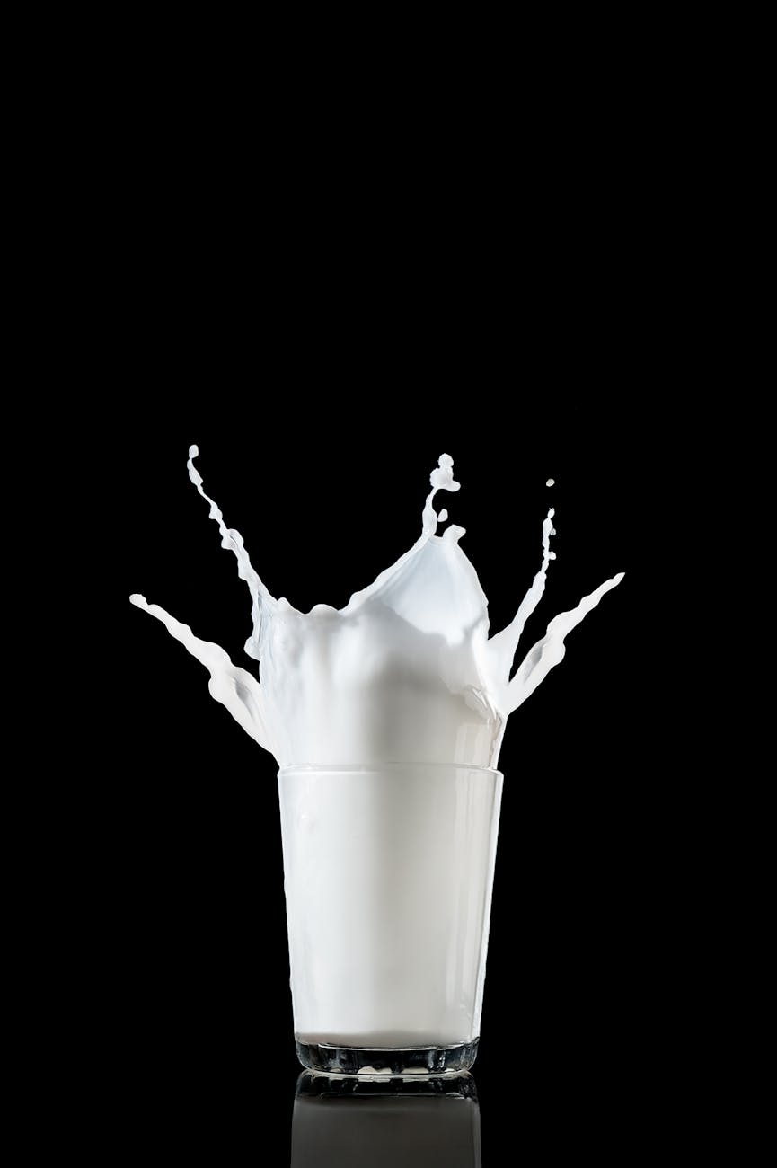 dynamic milk splash in glass on black background